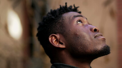 Young black African man looking up at the sky with HOPE and FAITH
