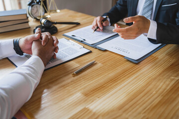 The business lawyer working about legal legislation in courtroom to help their customer, the Lawyer working with a client discussing contract paper