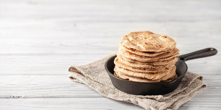 Homemade Indian Traditional Flatbread called Chapati on a white wooden background. Baked indian flatbread. Copy space
