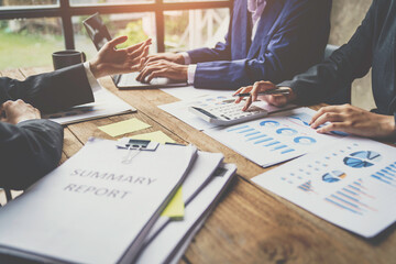 A business team consultant describes a marketing plan to set strategies for business owners using a calculator. business planning and business researching concepts.