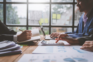 A business team consultant describes a marketing plan to set strategies for business owners using a calculator. business planning and business researching concepts.