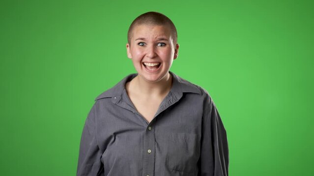 Portrait of gender fluid non binary young woman 20s years old posing isolated on green screen background studio. Cover mouth with hands on face say wow omg no way 