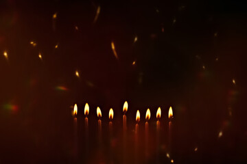 Religious image of Jewish holiday Hanukkah with candles of menorah with sparks from the fire in the...