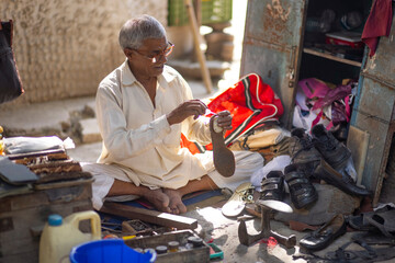A cobbler repairing shoes on the streets of Delhi