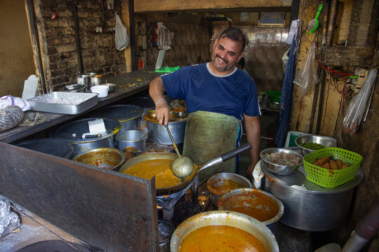 A cook and an owner of a local roadside restaurant or a  dhaba, cooking food during lunch hour