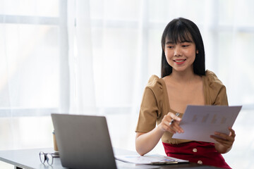 Asian Businesswoman working on laptop at her desk at the office.