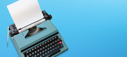 Retro typewriter with paper header with text space on blue background
