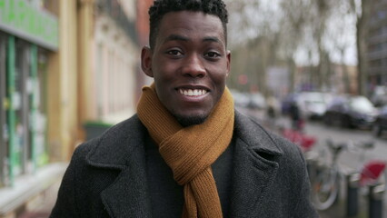 Young happy black African man walking outside