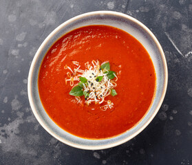 Overhead shot of pureed tomato soup garnished with grated parmesan