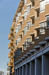 Obraz premium Utrecht, The Netherlands, November 13, 2022: sculptural facade of a housing block with balconies and bay windows in yellow brick in the center of Leidsche Rijn district