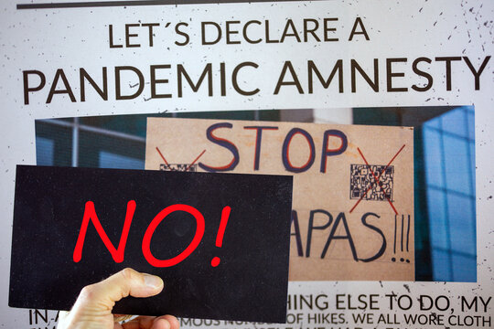 Symbolic image Pandemic Amnesty: Cut-out of a symbolic newspaper, a sign with the inscription NO is held in front of it. The photo in the background of the image is by the compositor himself