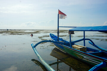 Fishing boat leaning on the beach. Fishing boat with Indonesian Flag