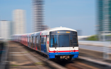 Naklejka na ściany i meble Motion blur of Sky train moving on elevated railway in downtown city at Bangkok, Thailand