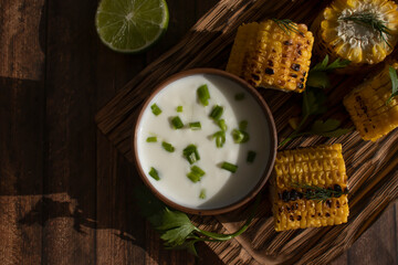 Grilled corn with sauce on old background