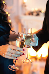 Close up shot of an elegant couple toasting glasses with champagne