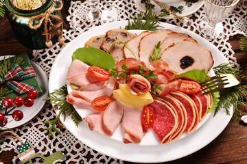 Christmas table with a platter of sliced ham and cured meat top view
