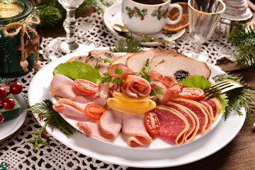 Christmas table with a platter of sliced ham and cured meat
