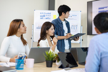 Professional marketer is making a presentation during a planning business meeting with colleagues. Meeting of diverse young entrepreneurs, talking, Businesspeople develop startup.