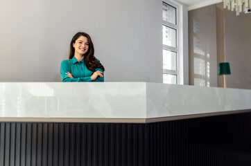 Portrait of female receptionist at desk in lobby.