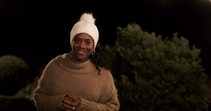 Portrait of smiling woman standing in backyard at night