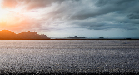 Asphalt road and sea with mountain nature background at sunrise