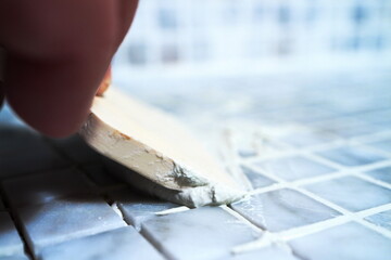Image of the process of filling the seams of tiled mosaic.