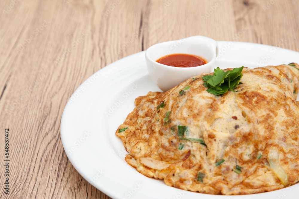 Wall mural Thai style omelette with minced pork, 
coriander and onion served with chilli sauce or Sriracha sauce