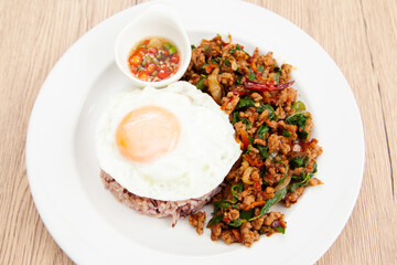 Rice with stir fried minced pork and basil topped with fried egg, Thai food called Pad Ka Prao Moo