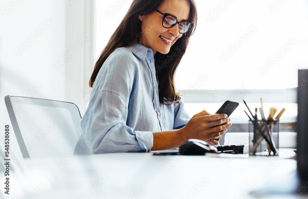 Poster Design professional reading a text message on her phone in an office