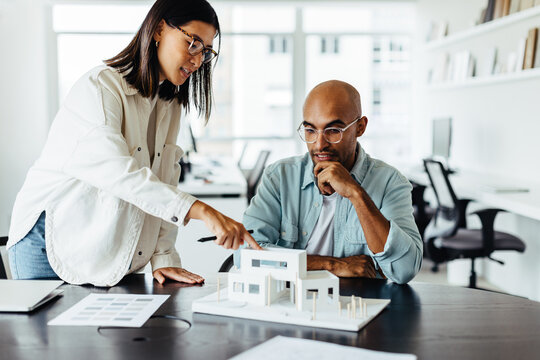 Business woman discussing an architectural model with her colleague