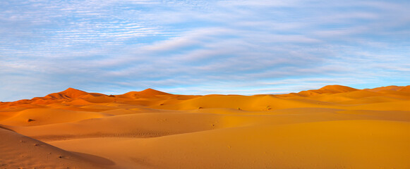 Naklejka na ściany i meble Beautiful sand dunes in the Sahara desert with amazing sunset sky - Sahara, Morocco