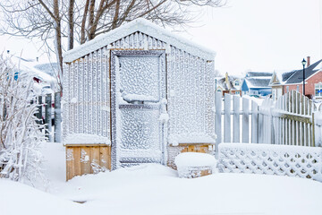 A home greenhouse in the backyard covered in snow after a snowstorm. - 548540628