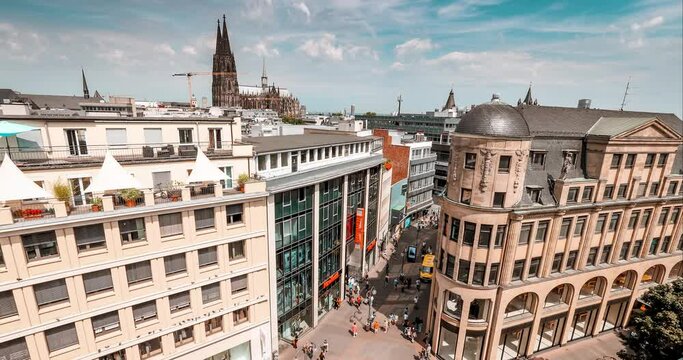 Aerial cityscape timelapse view of a popular shopping streets with crowds of people and Koln Cathedral in the back