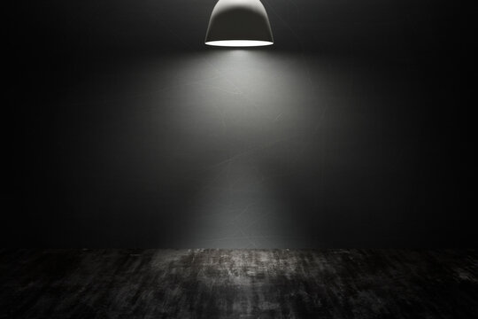Empty space of dark studio room with concrete wall and pendant lamp