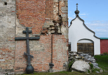 Old church in the Russian city of Volkhov. Restoration is underway now. The metal cross is leaning against the wall.