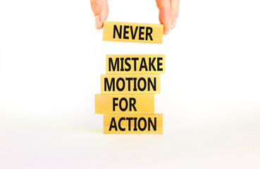 Mistake or action symbol. Concept words Never mistake motion for action on wooden blocks. Businessman hand. Beautiful white table white background. Business mistake or action concept. Copy space.