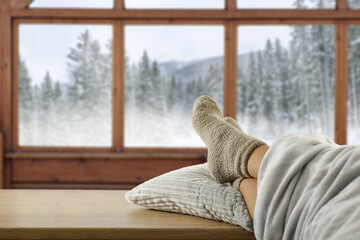 Woman legs with socks and wooden winter background. 