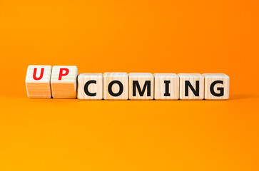 Coming or upcoming symbol. Concept words Coming and Upcoming on wooden cubes. Beautiful orange table orange background. Business coming or upcoming concept. Copy space.