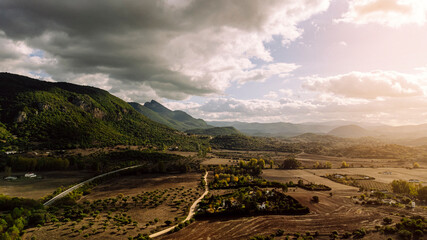Tomas aereas de zona campestre junto a mota&ntilde;as y parque natural al atardecer 