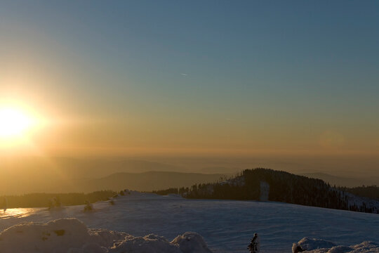 Ausblick vom Großen Arber an einem kalten und wolkenlosen Winterabend bei Sonnenuntergang
