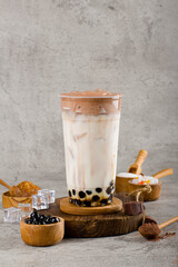 Boba or tapioca pearls is taiwan bubble milk tea in plastic cup with dalgona coffee flavor on texture  background, summers refreshment.