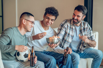 Joyous guy regaling his friends with a snack