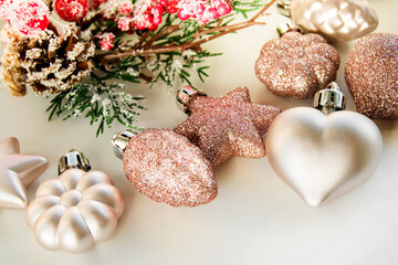 Christmas toys - pink shiny balls on a light background and a defocused foreground. New Year or Christmas card, invitation.