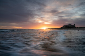 Bamburgh castle viewed at sunrise, located on the northumberland coastline.