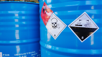 Flammable, acid, volatile, warning labels, mounted on hazardous chemical storage tanks in the warehouse of a chemical industrial factory plant. Waiting for delivery according to the user's order. - obrazy, fototapety, plakaty