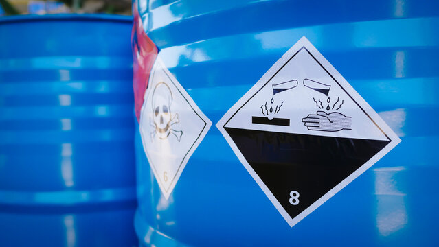 Flammable, acid, volatile, warning labels, mounted on hazardous chemical storage tanks in the warehouse of a chemical industrial factory plant. Waiting for delivery according to the user's order.