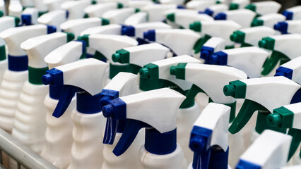 Obraz premium sprayer bottle. Group of white sprayer bottles high angle view. Cleaning equipments concept. Selective focus included