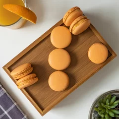 Zelfklevend Fotobehang Top view of orange-colored French macarons in a wooden box on a table © Pjm Captures/Wirestock Creators