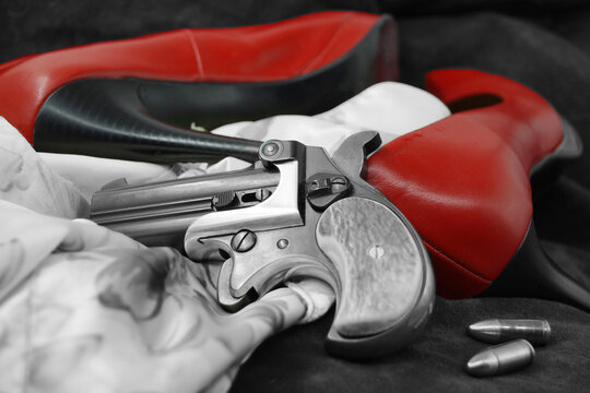 A double barrel derringer style pistol in black and white. This kind of weapon was used by gamblers and women in the past because of its small