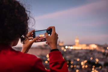 Tourist photographing Toledo at sunset